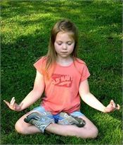 Little girl meditating on grass